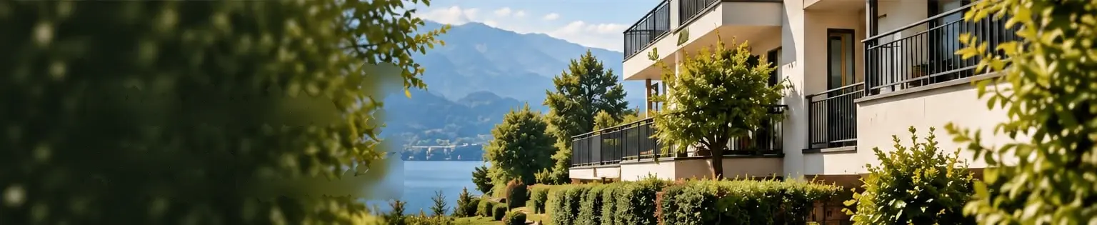 Gepflegte Liegenschaft mit Balkonen, See und Bergen im Hintergrund